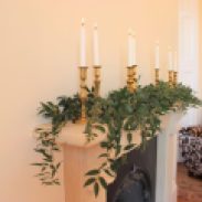 Brass candlesticks, white and foliage mantelpiece decor, styling by Elizabeth Weddings